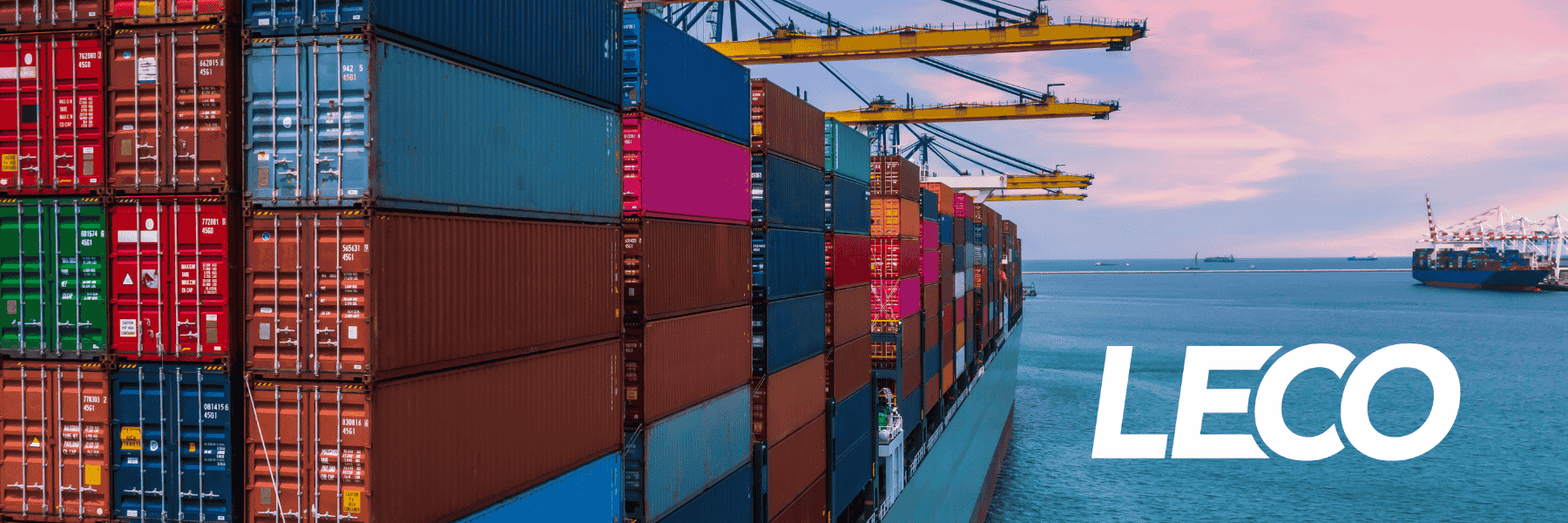 Cargo ship with shipping containers piled on top at sunset
